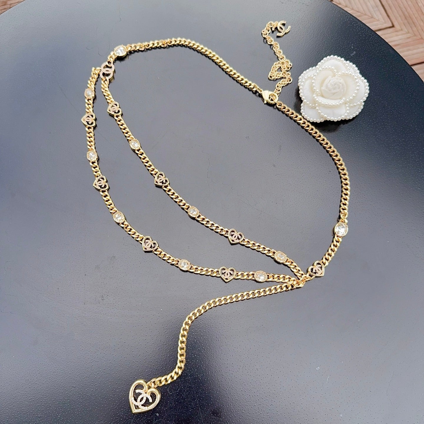 Chanel belt with gold-tone chain, heart charm accents, and white flower center detail