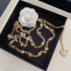 Chanel belt with gold-tone chain, heart charms with crystals, and white flower clasp