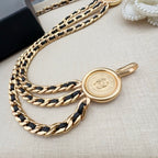 Gold-tone chain belt with round logo coin charm and toggle clasp detail