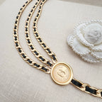 Gold-tone chain belt with round logo coin charm and braided chain strands
