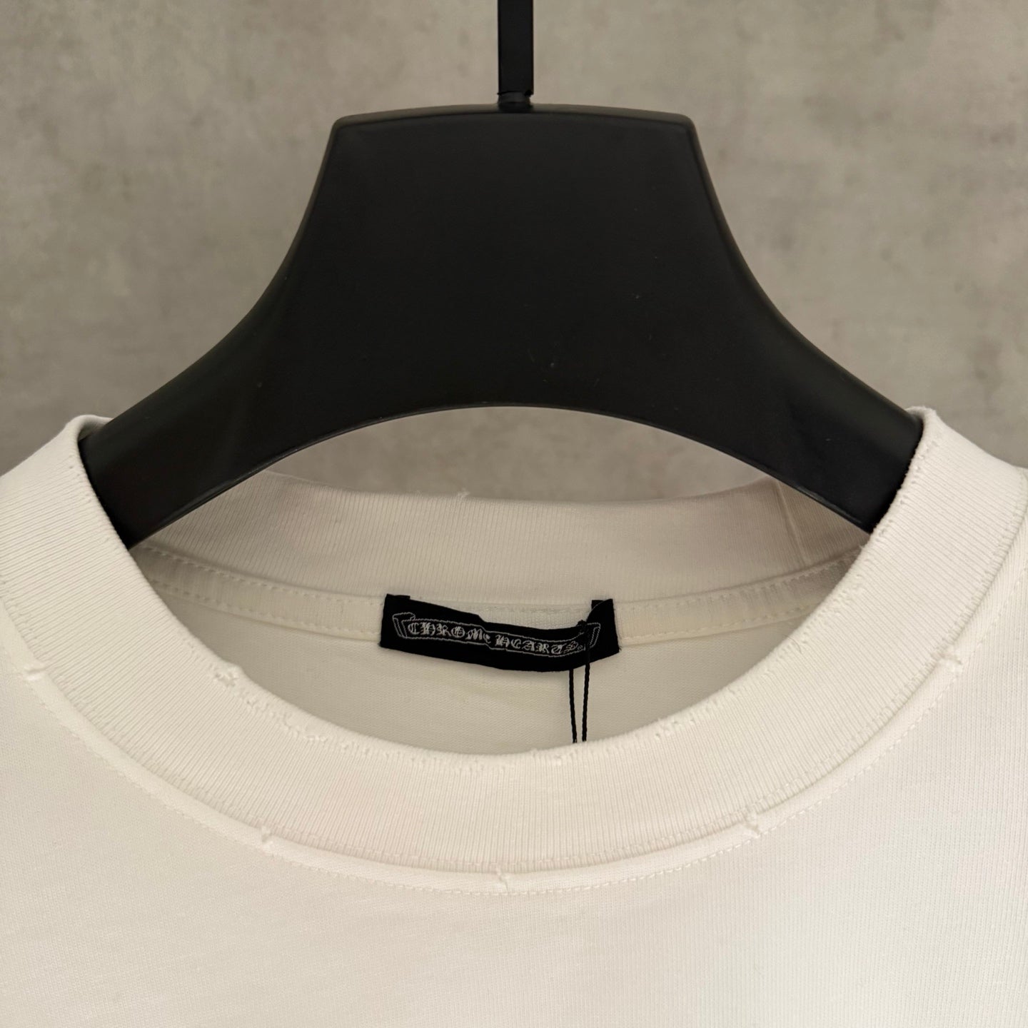 White T-shirt neckline with black brand label inside collar