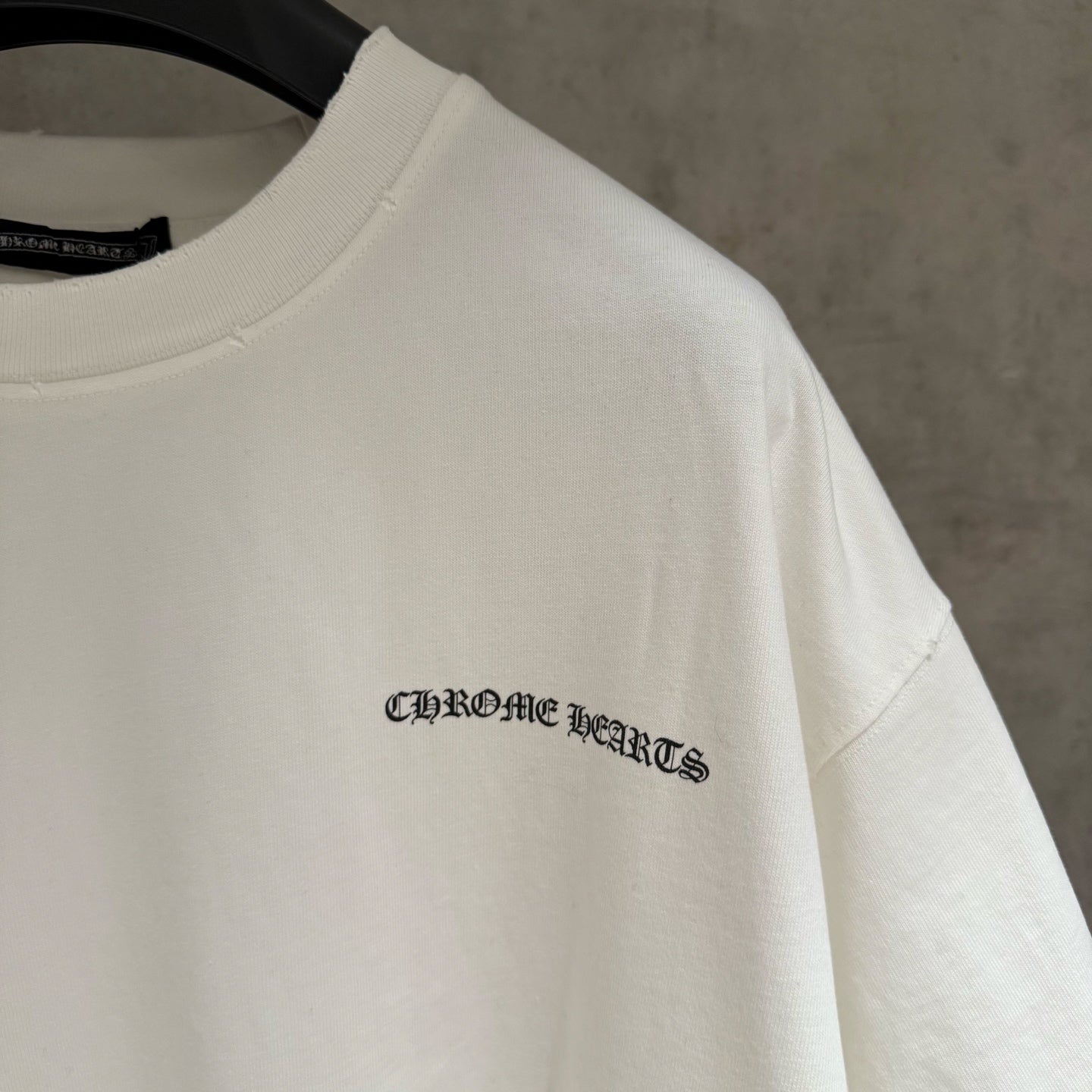 White short-sleeve T-shirt with small logo on the sleeve