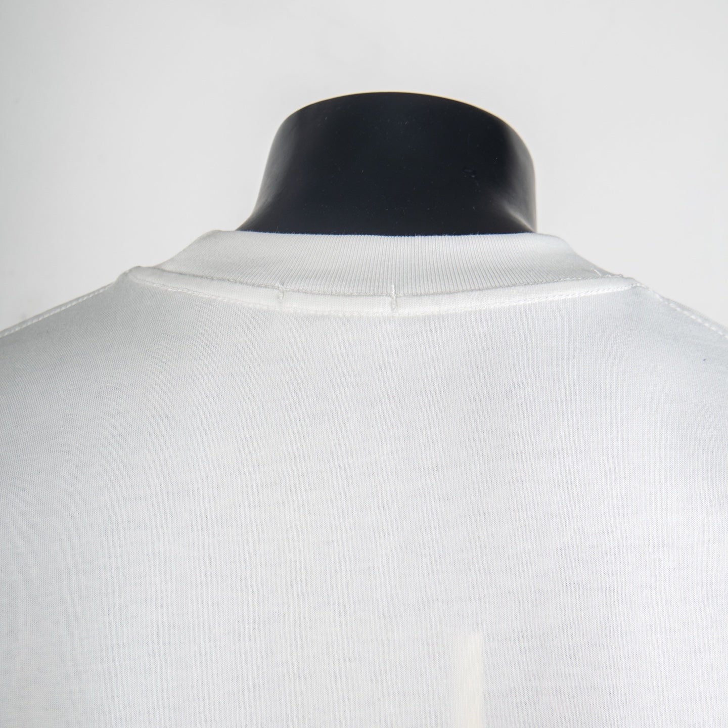 White T-shirt neckline and yoke seam detail.