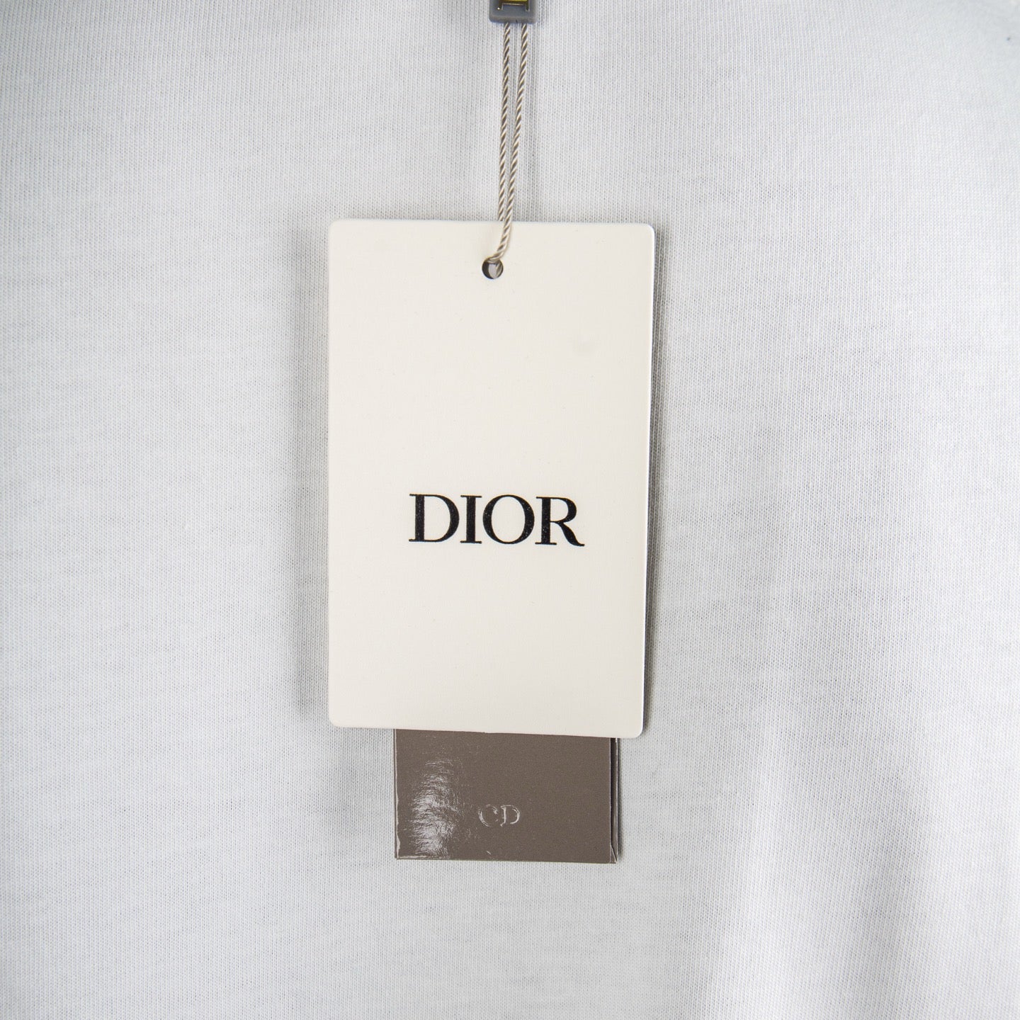 White T-shirt with Dior hang tag near neckline.