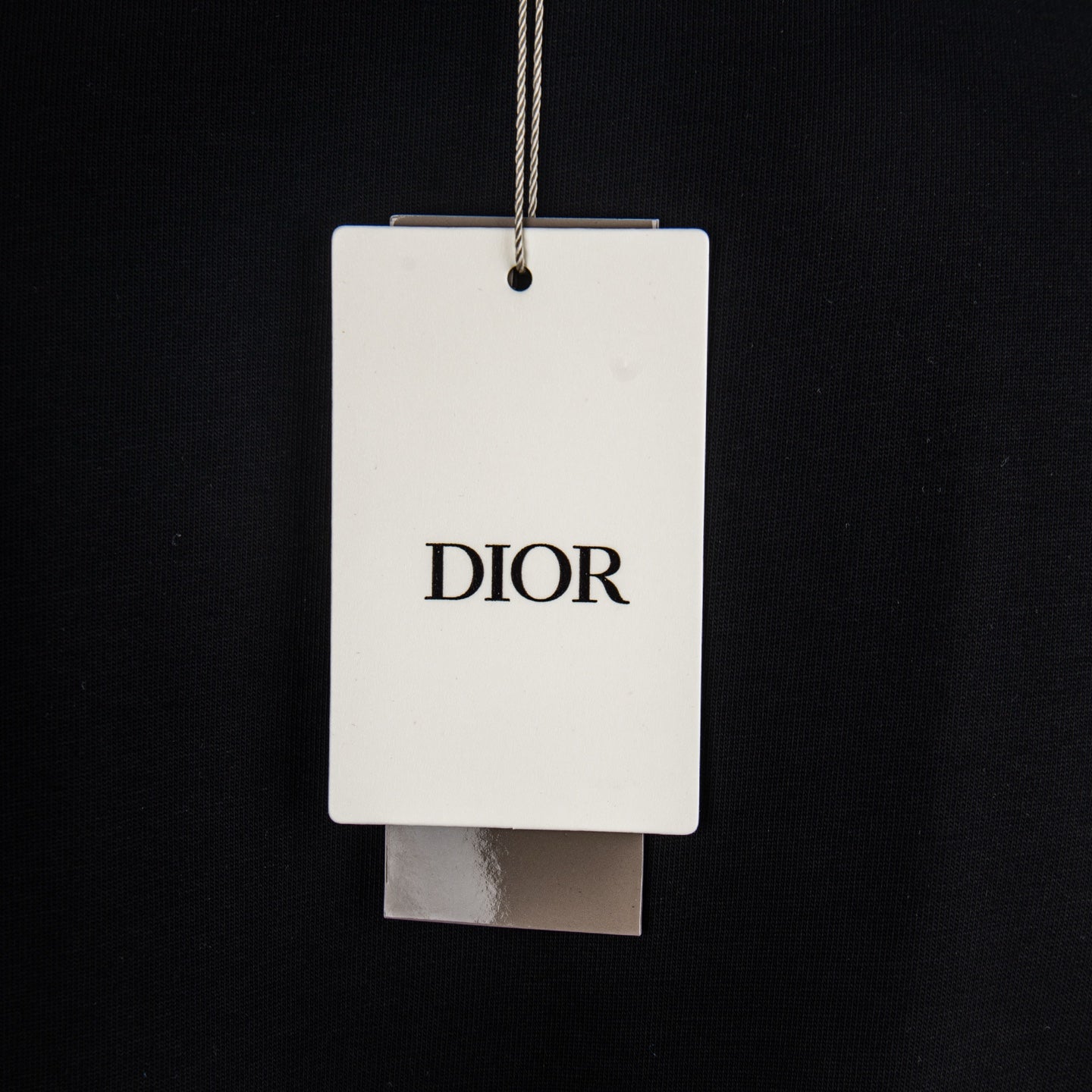 Black T-shirt with hanging retail tag marked DIOR