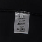 Black T-shirt care label with size M and fabric details