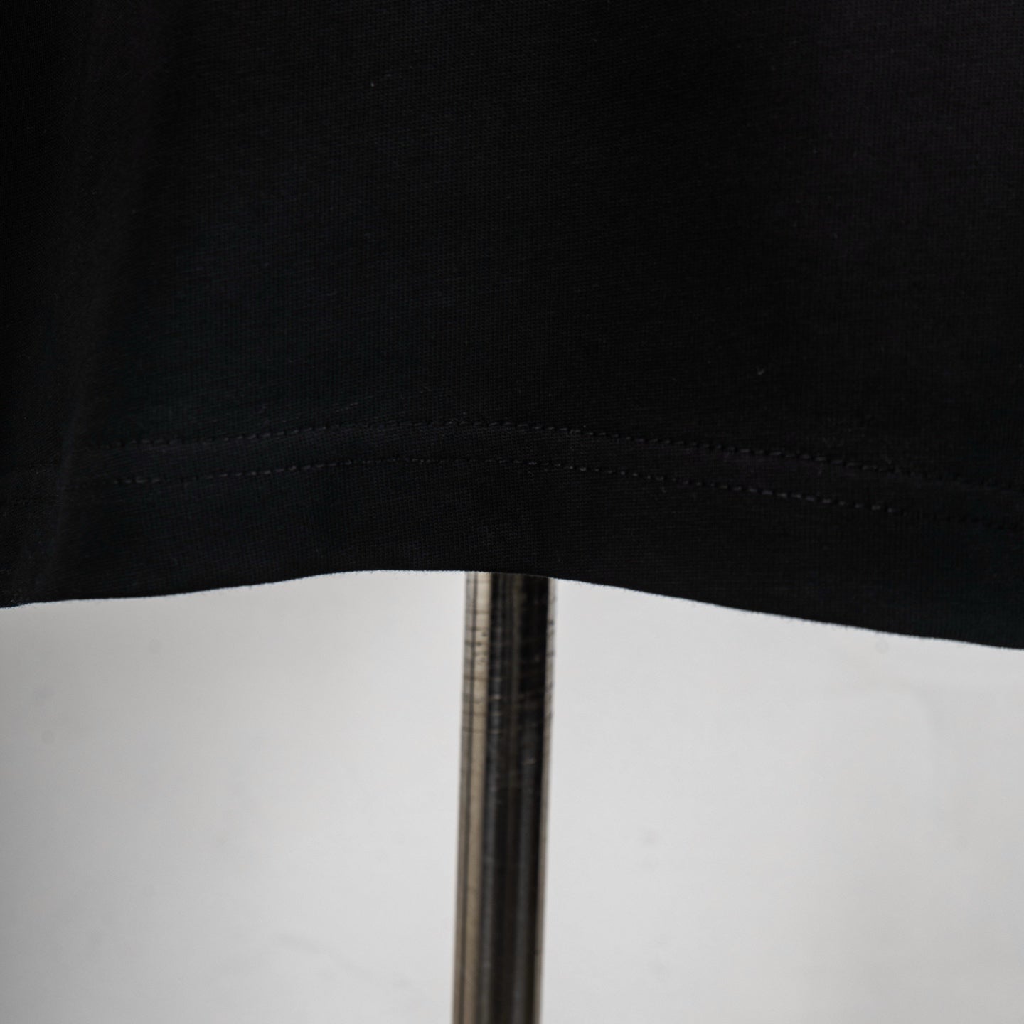 Black T-shirt hem and bottom seam close-up
