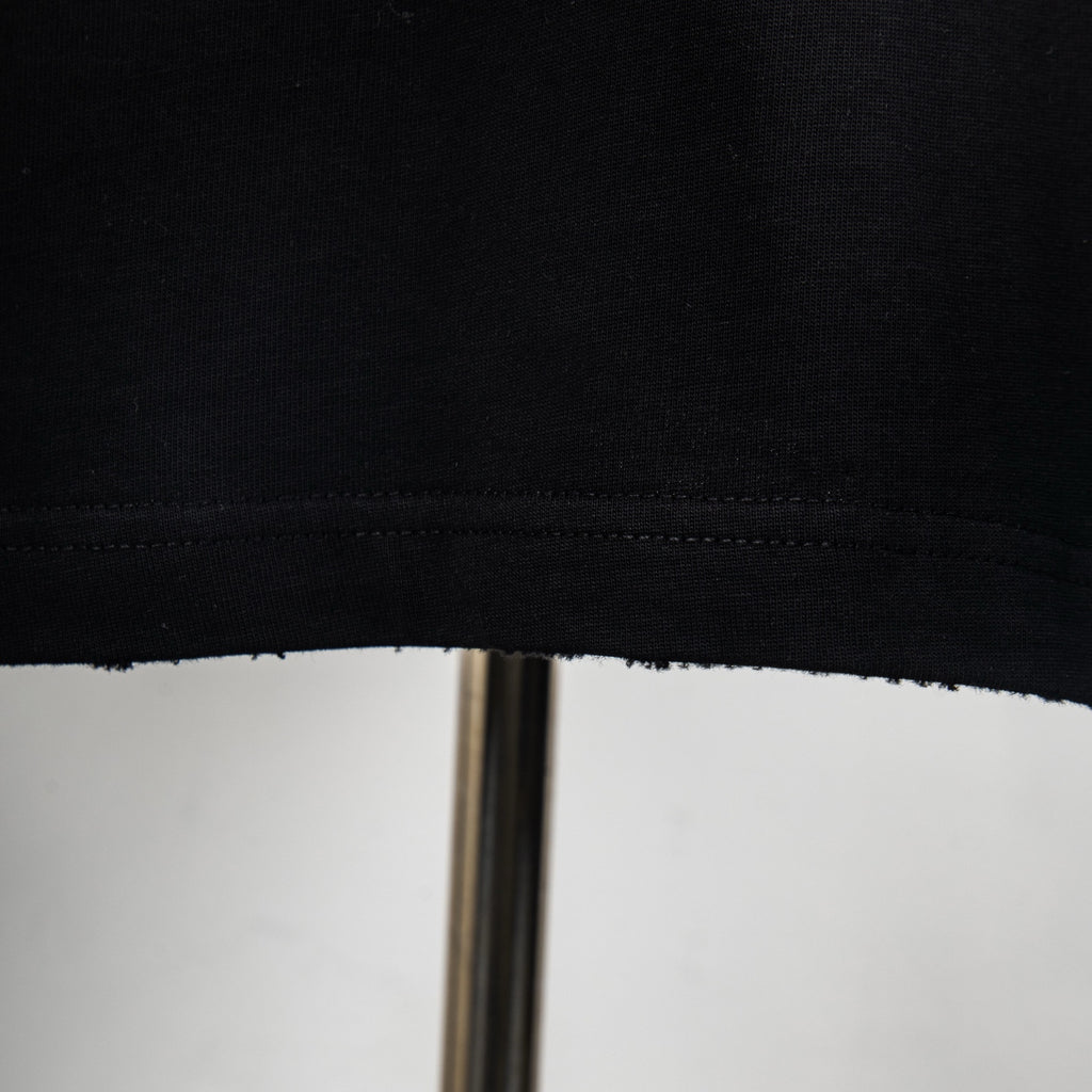 Black T-shirt hem with visible stitching