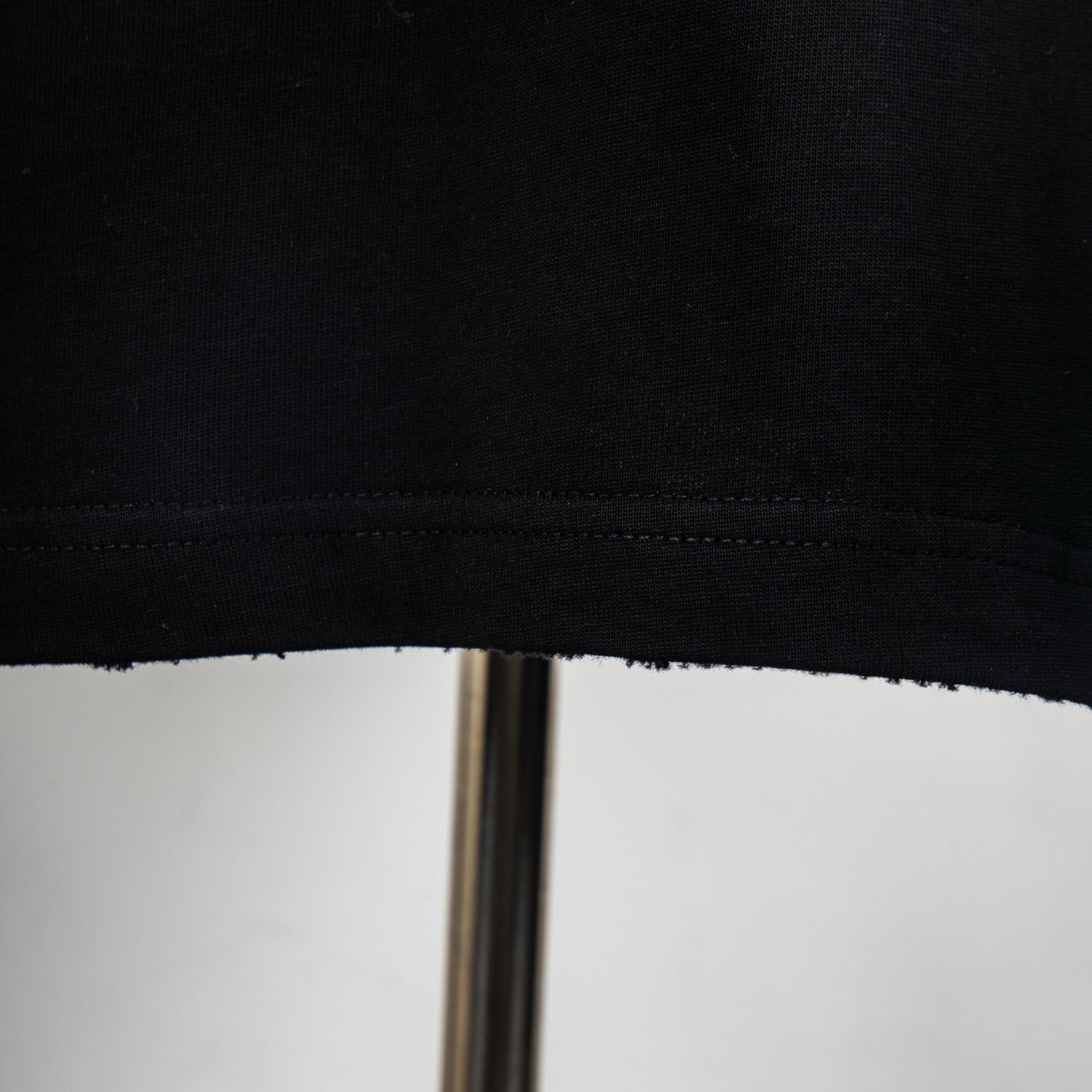 Black T-shirt hem with visible stitching