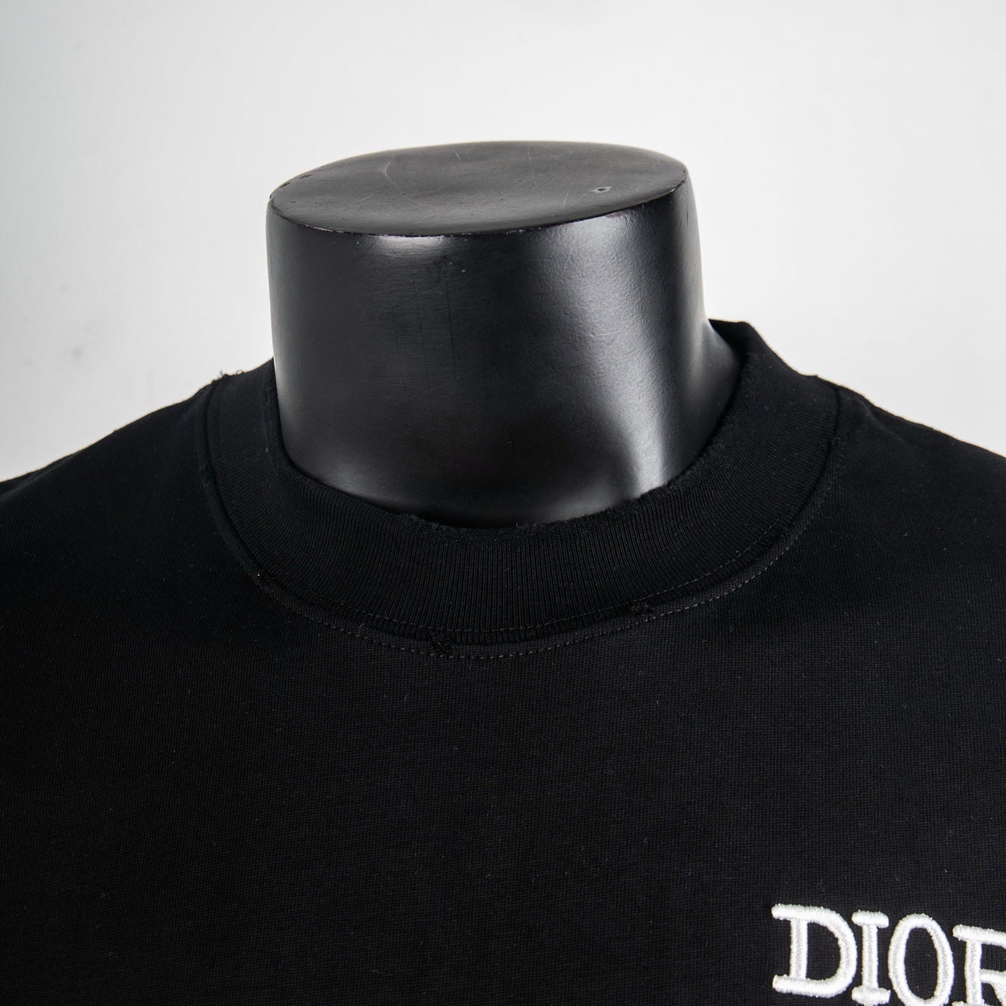 Black short-sleeve T-shirt with neckline detail and partial DIOR logo