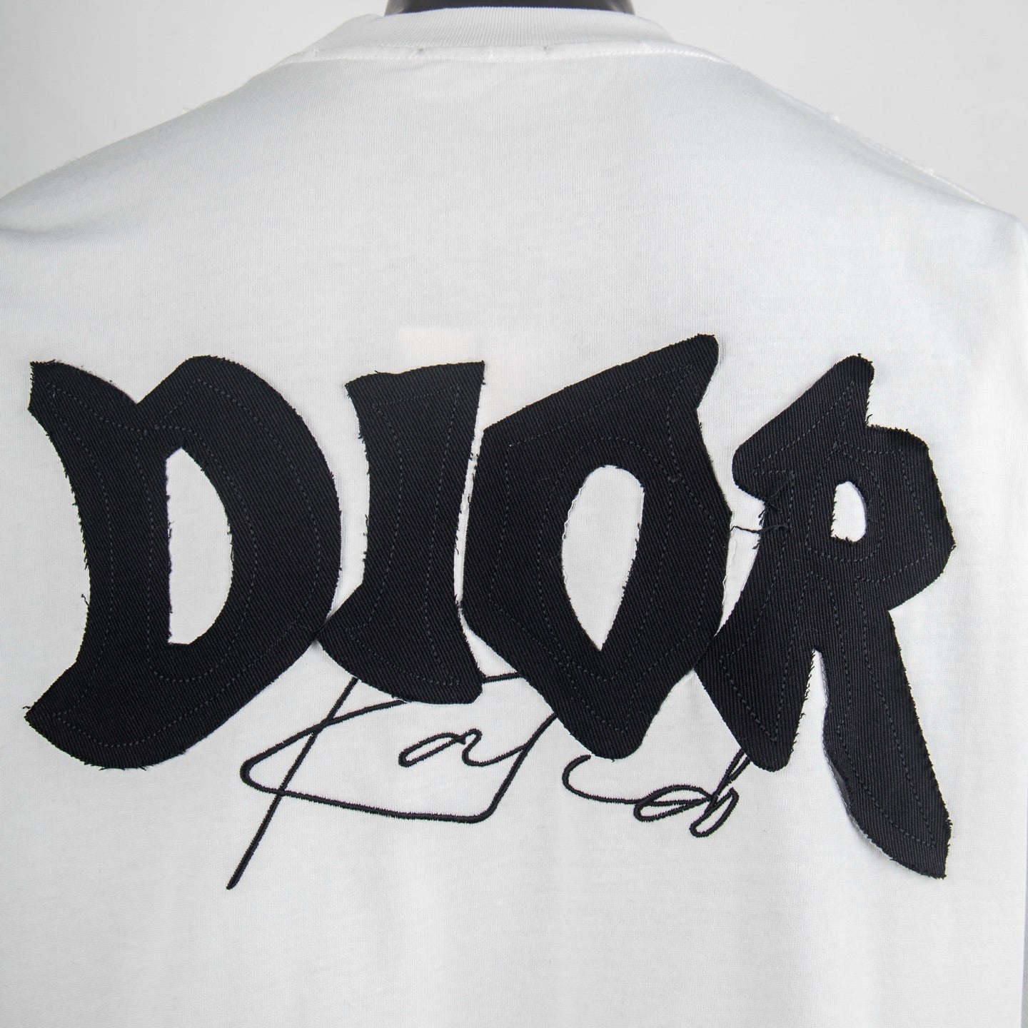 Close-up of large black back logo graphic on white crewneck T-shirt