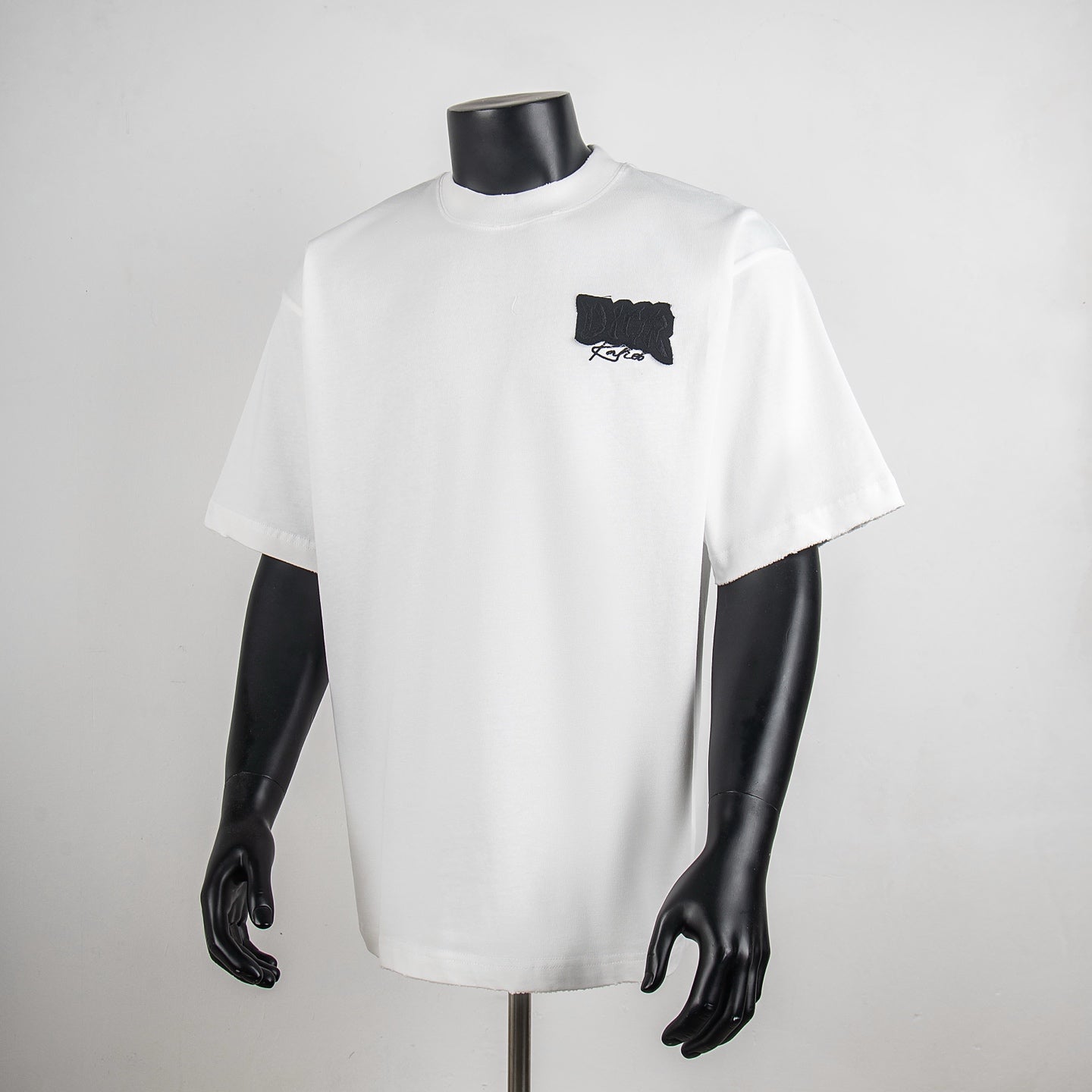 White crewneck short-sleeve T-shirt with small black embroidered logo on chest