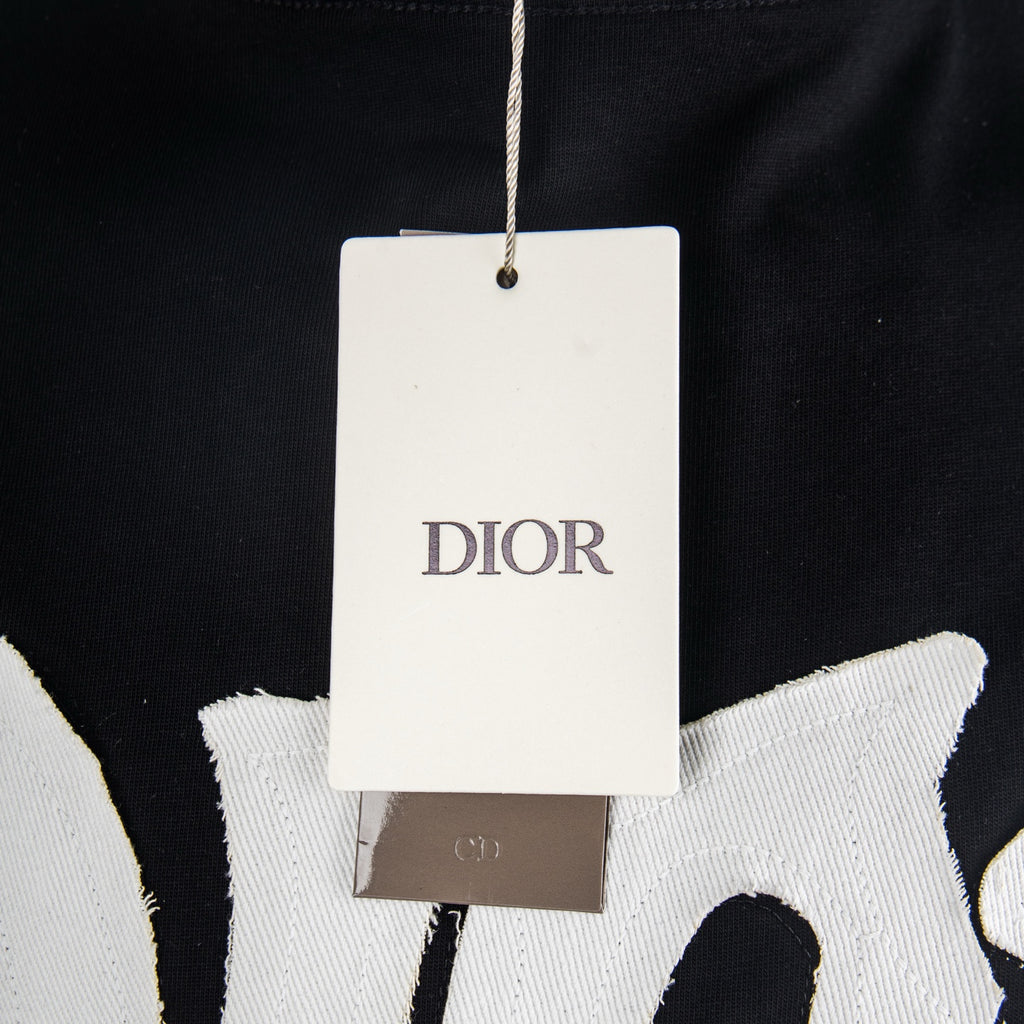 Black T-shirt with hanging white retail tag near neckline