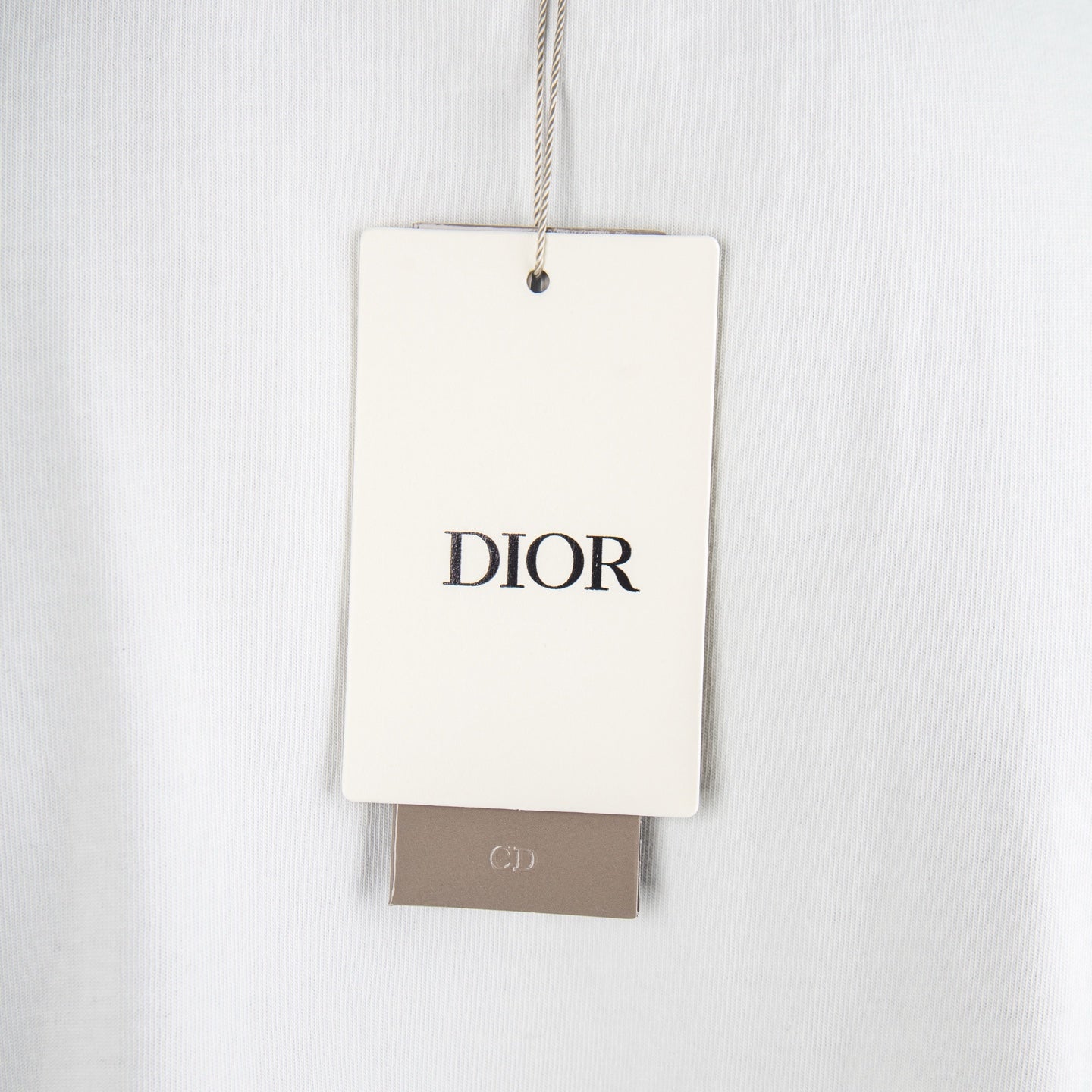 White fabric garment tag reading DIOR