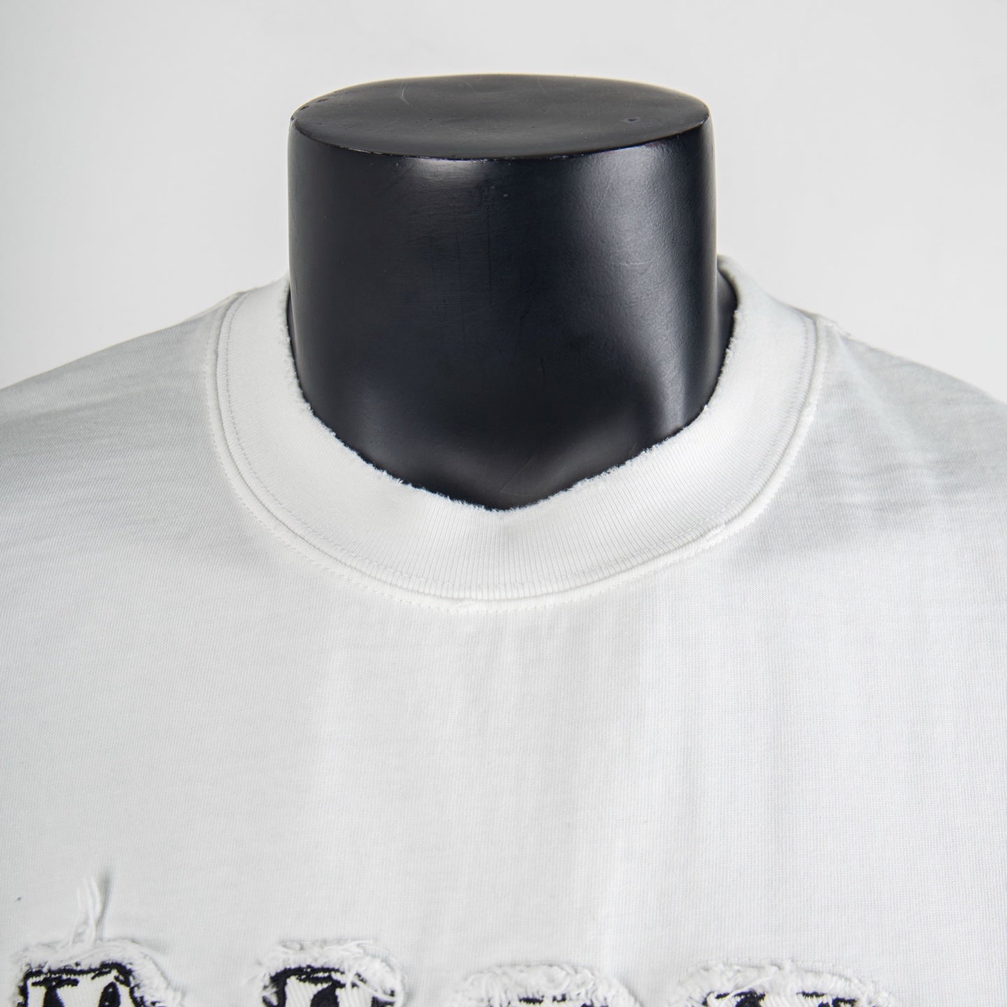 White T-shirt neckline close-up with black logo detail