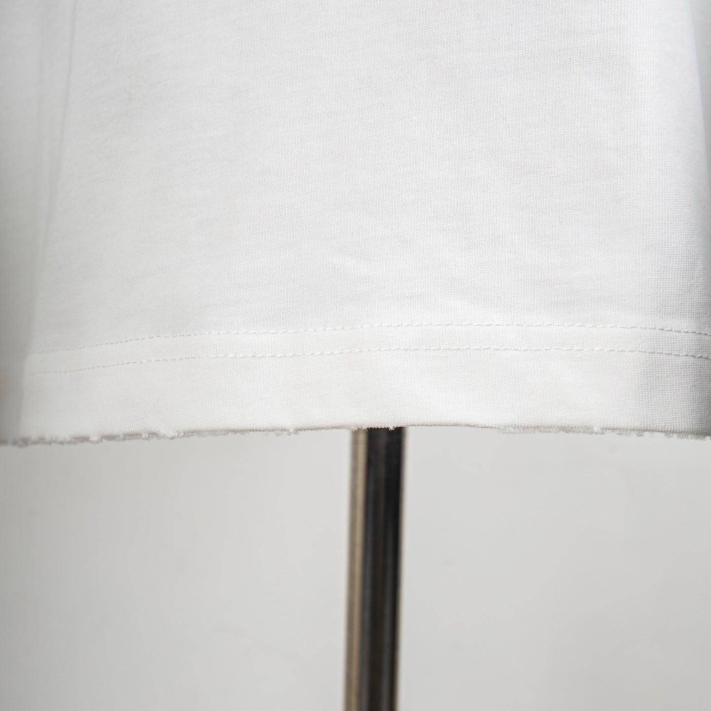 Dior white T-shirt hem close-up with double-stitched seam