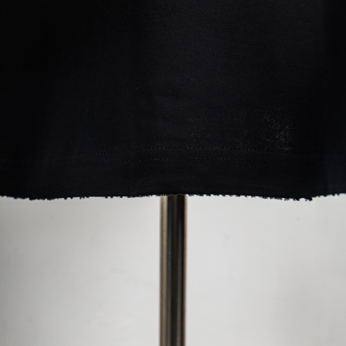 Black T-shirt hem with visible stitching