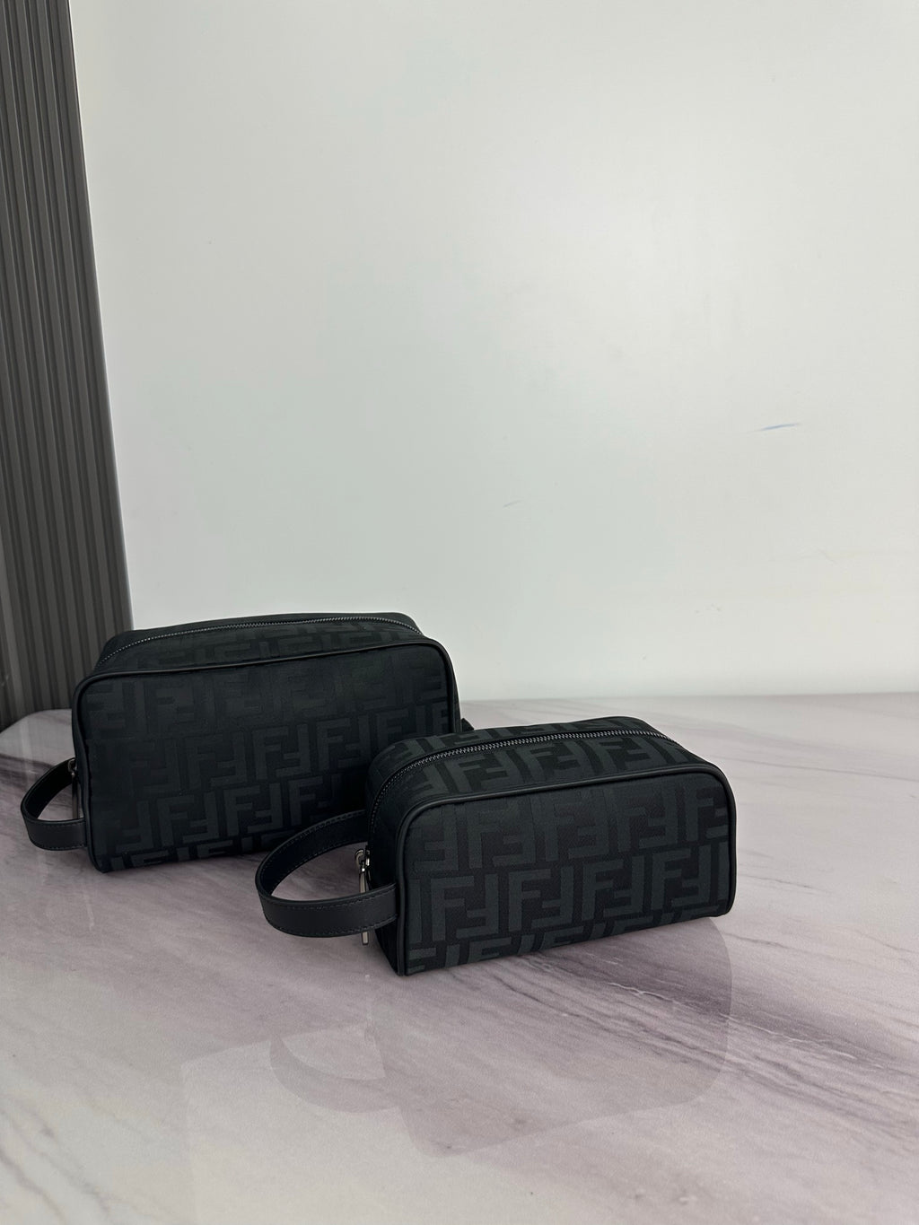 Fendi dark crossbody bag with repeating FF logo pattern and curved top zip