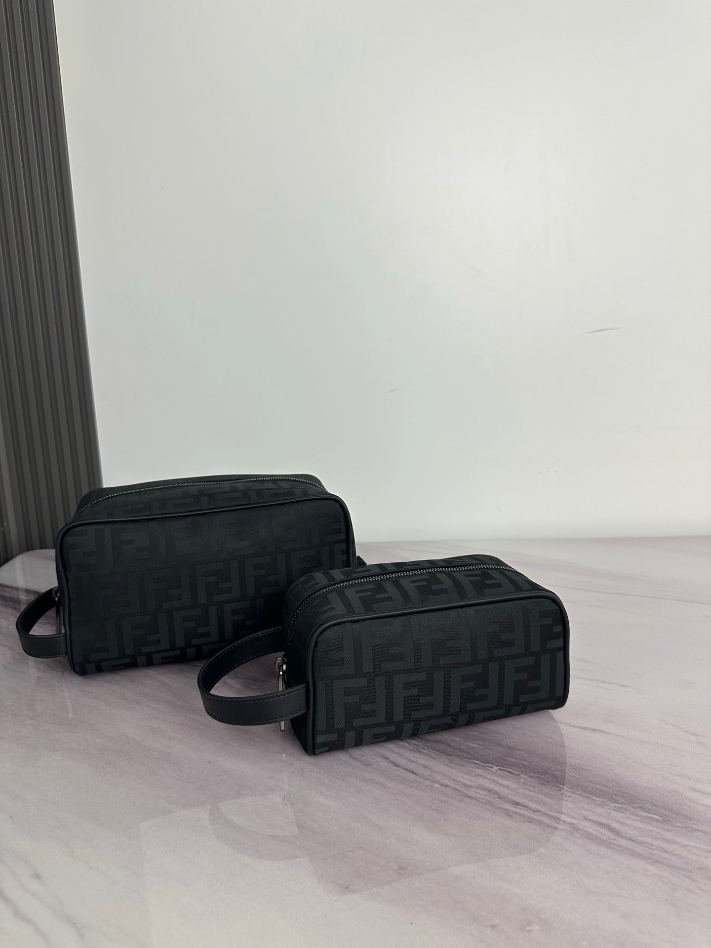 Fendi dark crossbody bag with repeating FF logo pattern and curved top zip