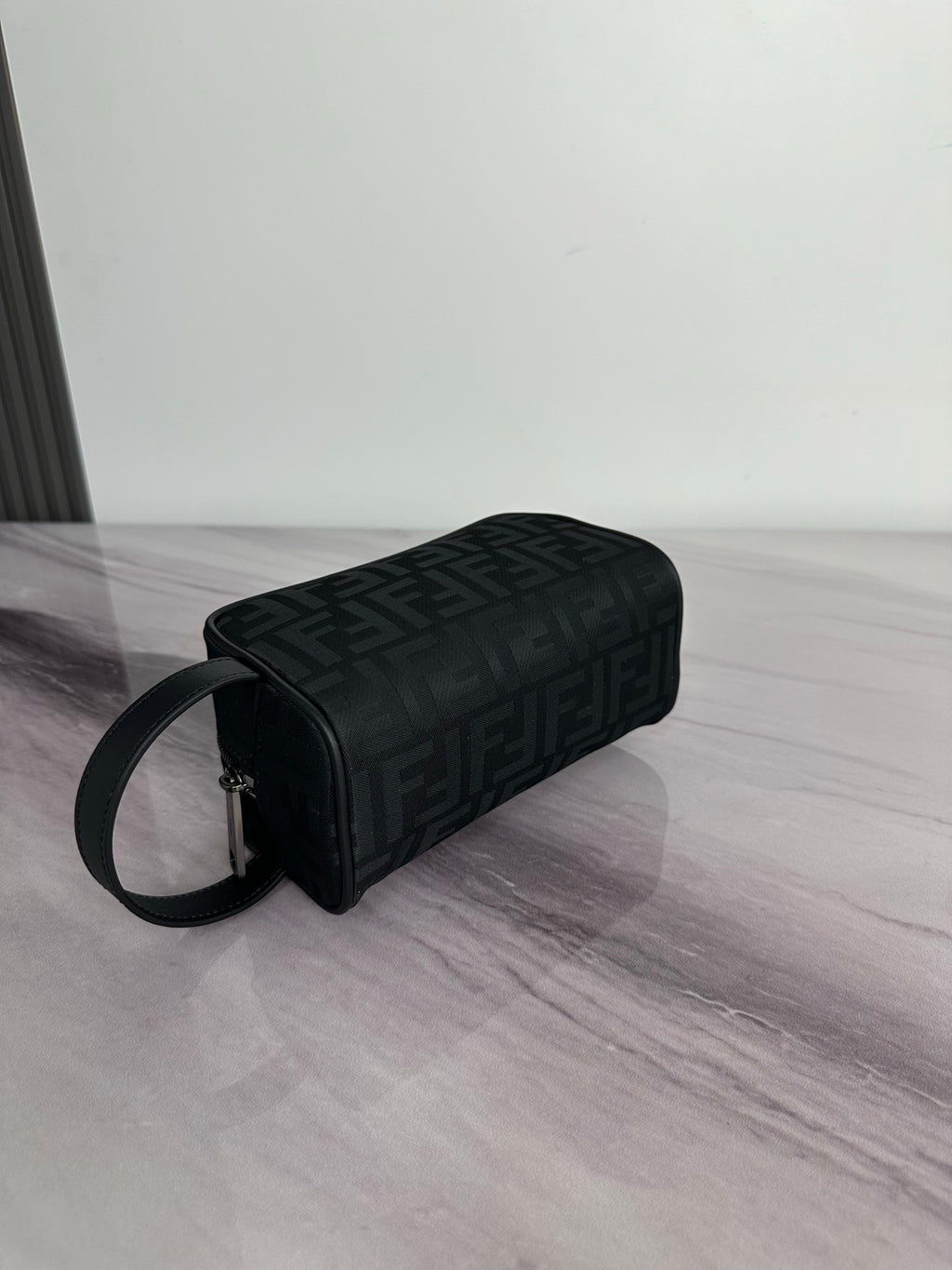 Fendi crossbody bag with dark monogram fabric, cylindrical profile, zip top, strap