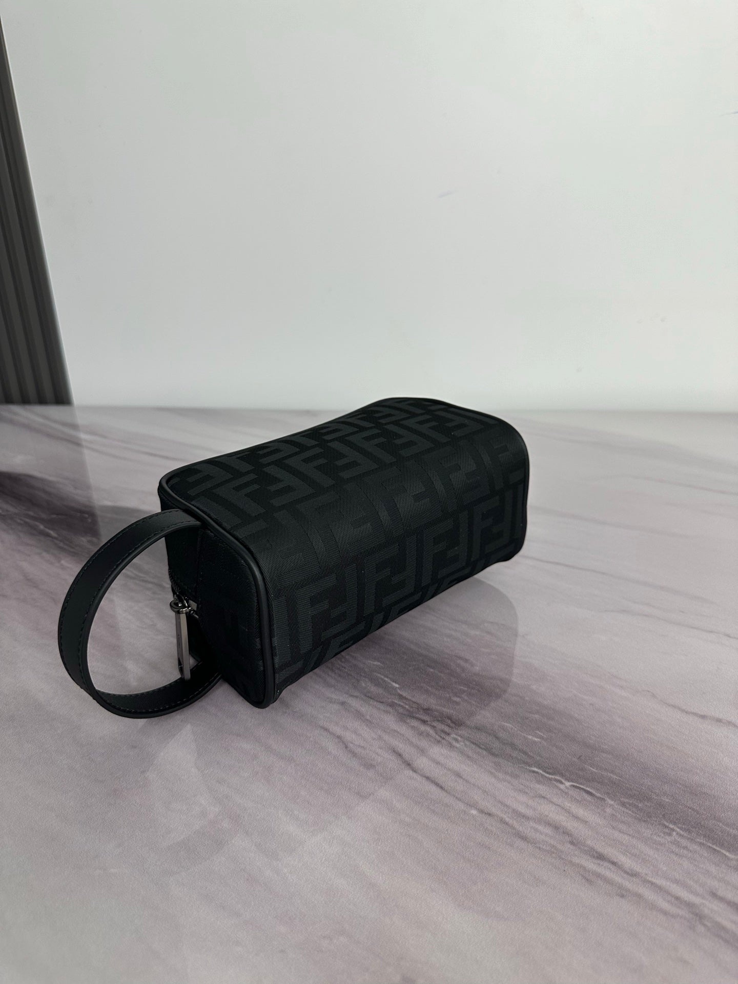 Fendi crossbody bag with dark monogram fabric, cylindrical profile, zip top, strap