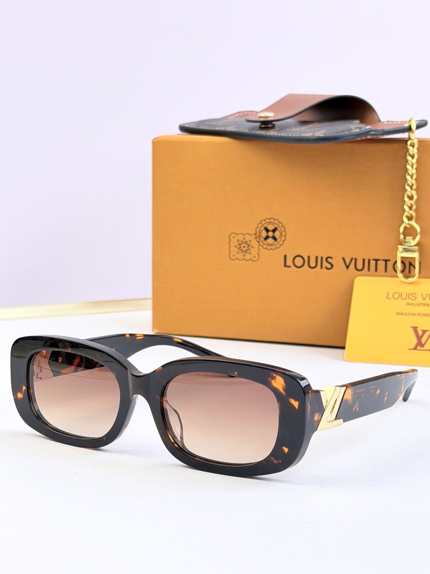 Louis Vuitton sunglasses with dark frames and light brown-tinted lenses, gold temple accents.