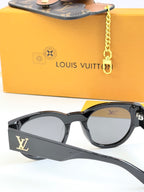 Louis Vuitton black sunglasses close-up with LV side logo and gray tinted lenses