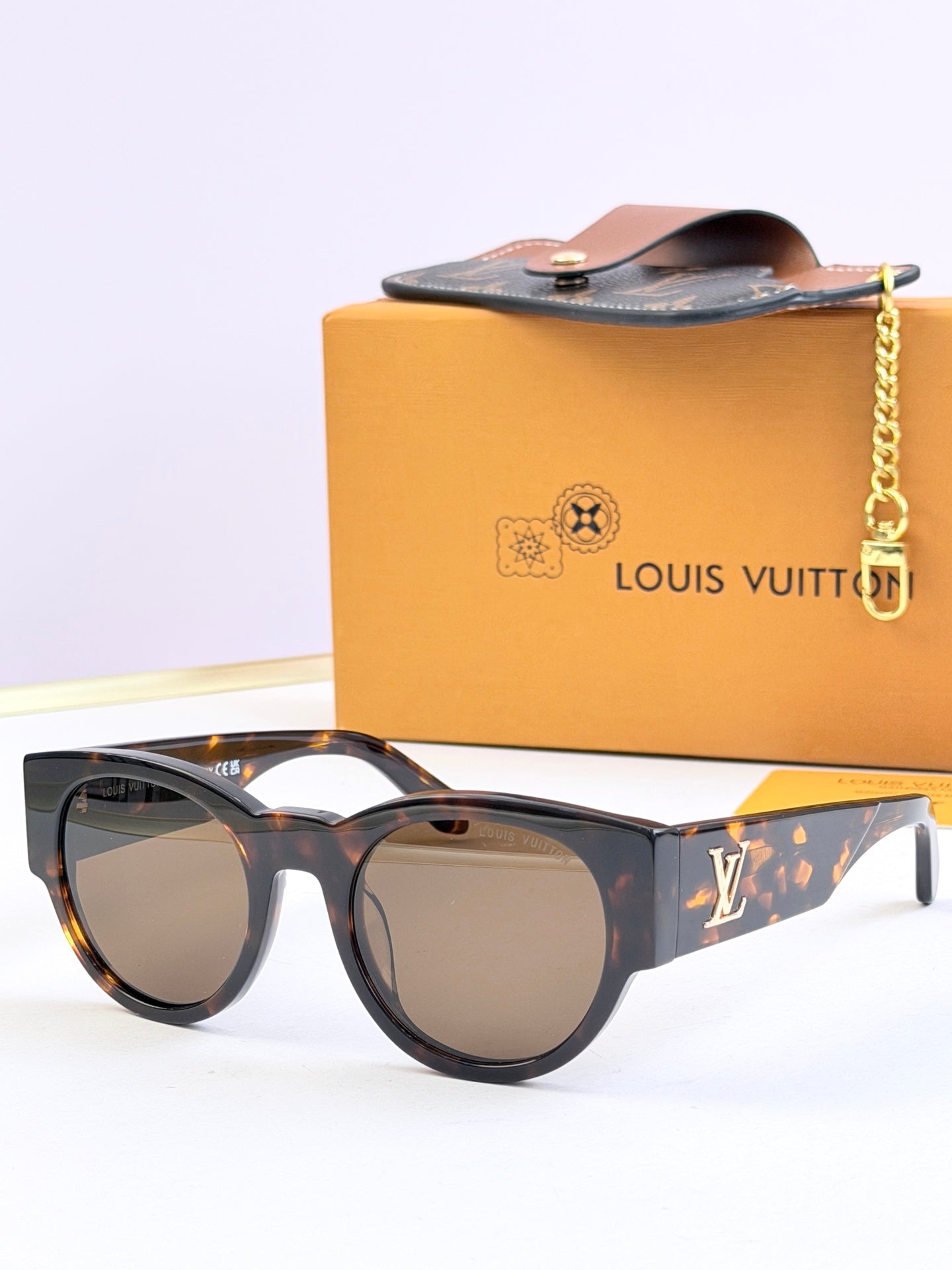Louis Vuitton tortoise sunglasses with gold-tinted lenses and LV side logo