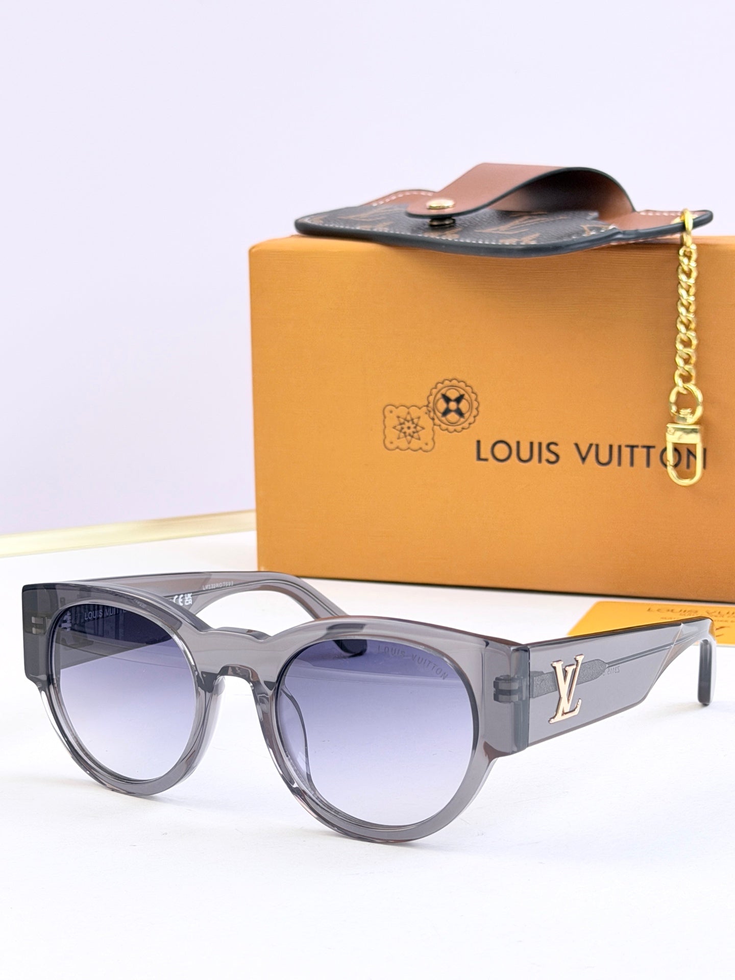 Louis Vuitton gray sunglasses with light blue tinted lenses and LV side logo