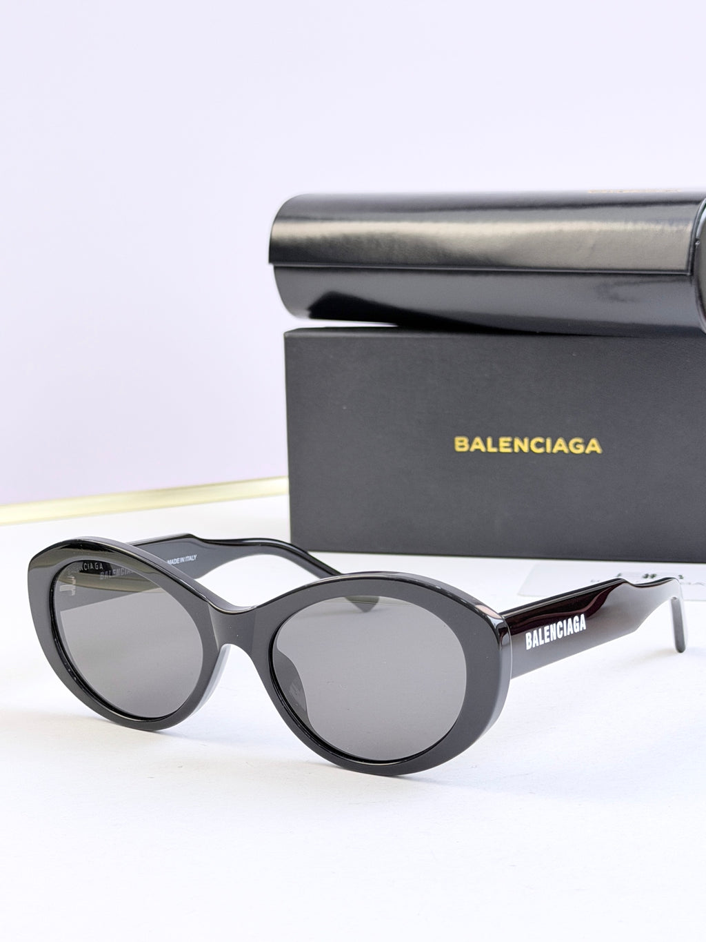 Oversized round sunglasses with dark gray lenses and black frame, BALENCIAGA logo