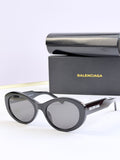 Oversized round sunglasses with dark gray lenses and black frame, BALENCIAGA logo