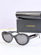 Oversized round sunglasses with dark gray lenses and black frame, BALENCIAGA logo