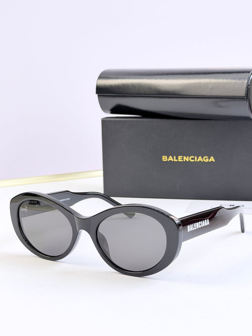 Oversized round sunglasses with dark gray lenses and black frame, BALENCIAGA logo