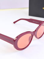 Pink round sunglasses with peach-tinted lenses and BALENCIAGA logo on temple