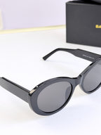 Black round sunglasses from side view with gray lenses and curved temples