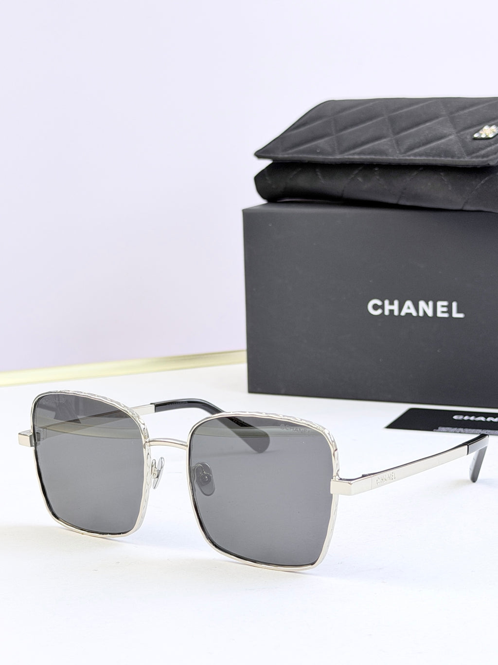 Chanel square sunglasses with silver frames and dark gray tinted lenses