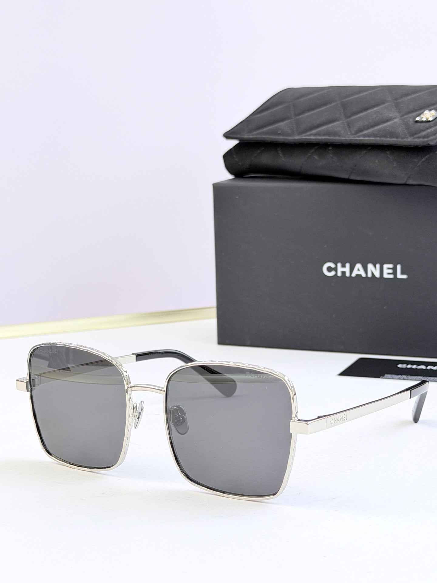 Chanel square sunglasses with silver frames and dark gray tinted lenses