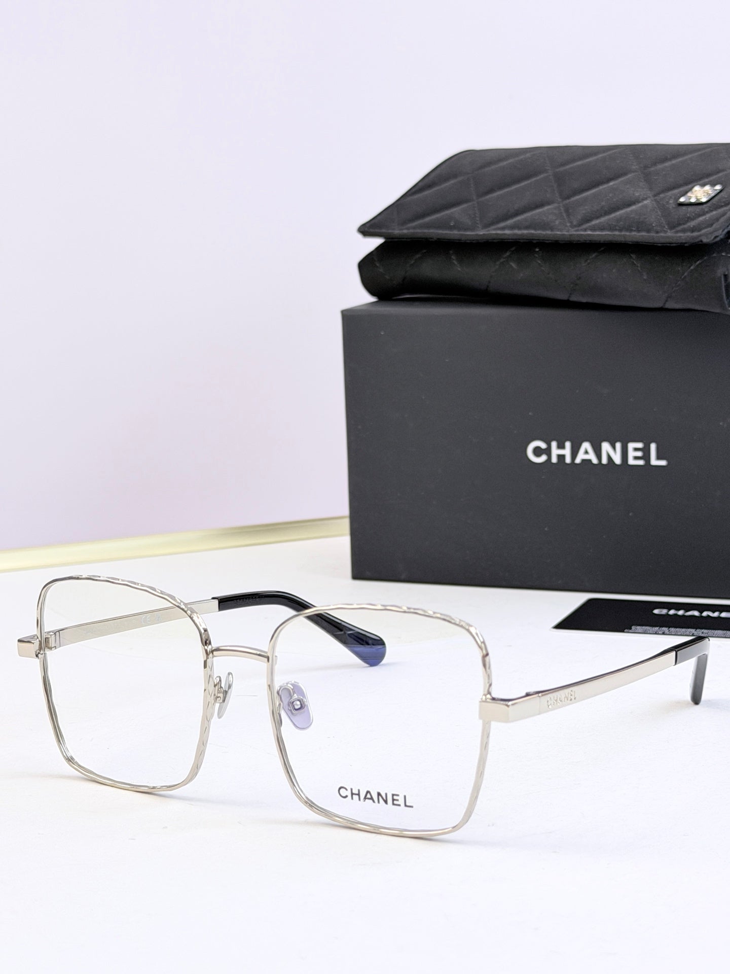 Chanel square eyeglasses with clear frames and subtle blue tinted lenses