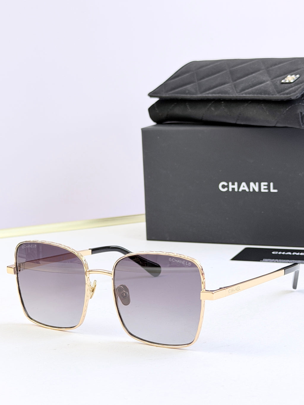 Chanel square sunglasses with gold frames and purple tinted lenses