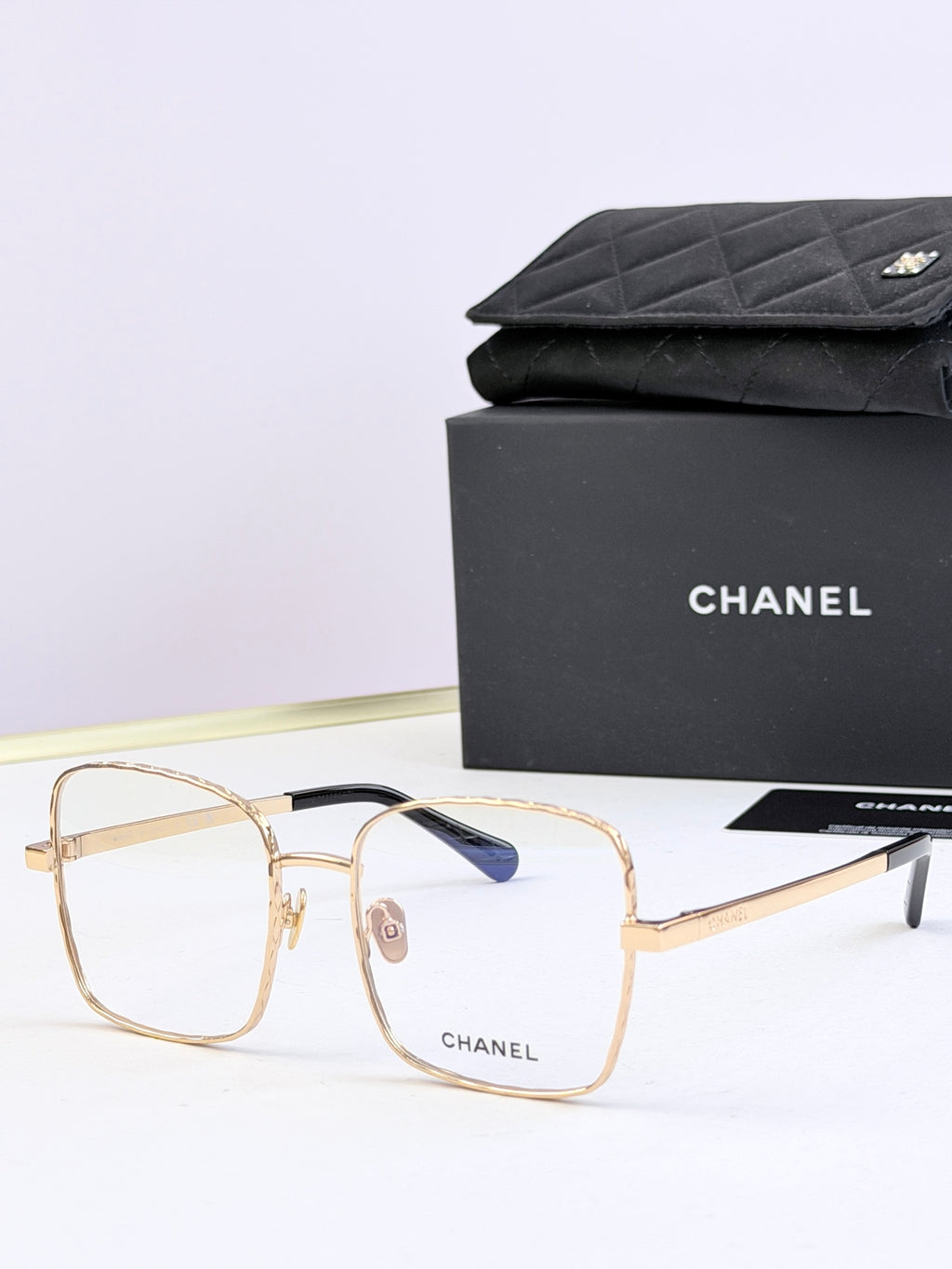 Chanel square eyeglasses with gold frames and subtle blue tinted lenses