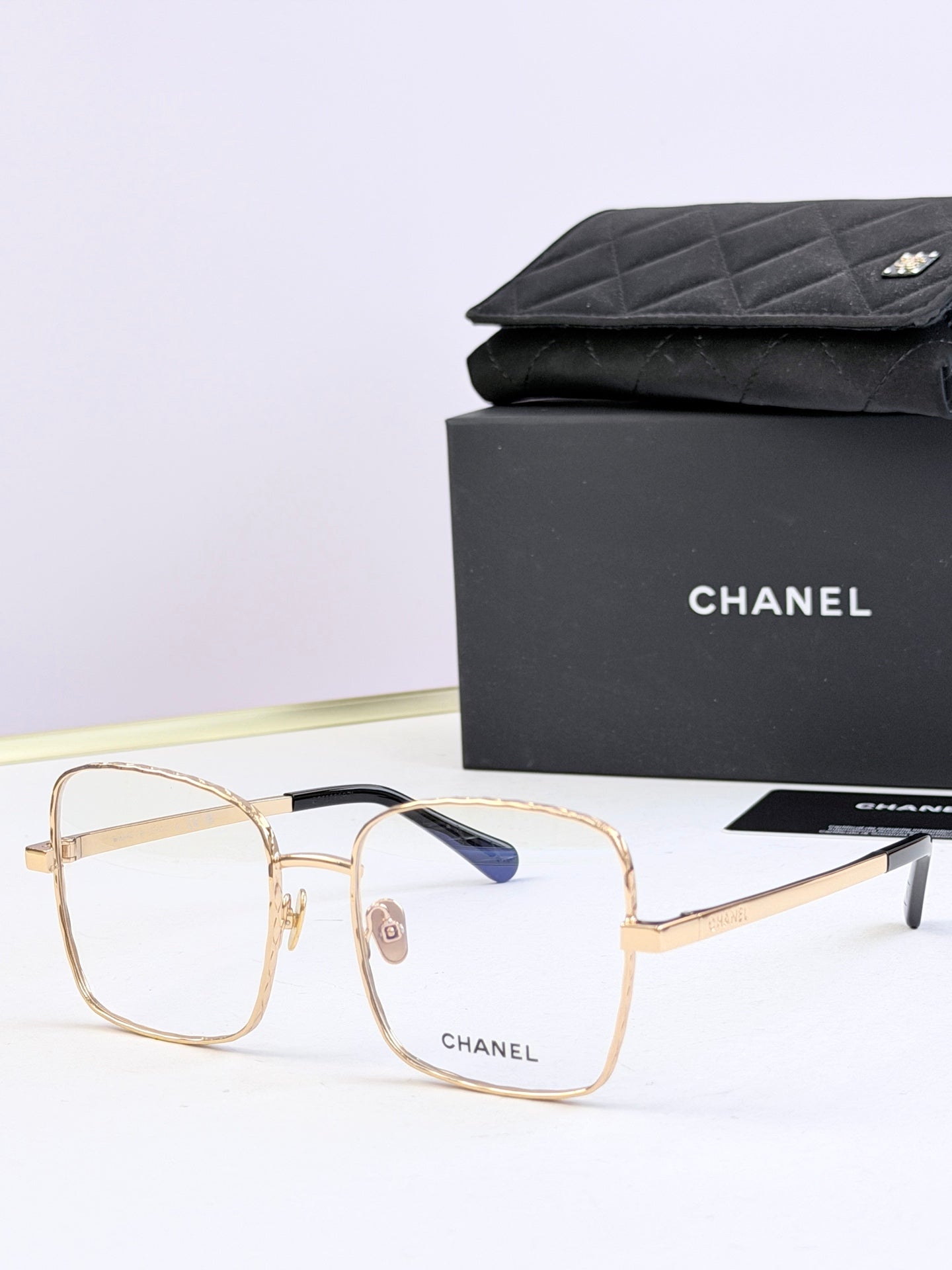 Chanel square eyeglasses with gold frames and subtle blue tinted lenses