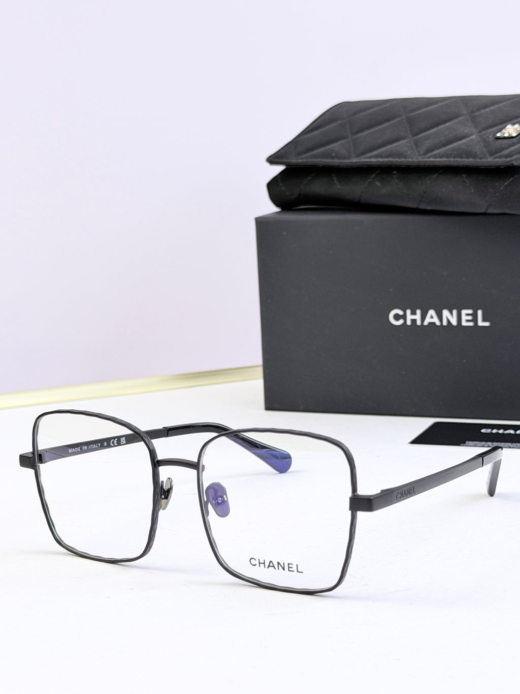 Chanel square eyeglasses with black frames and blue tinted lenses