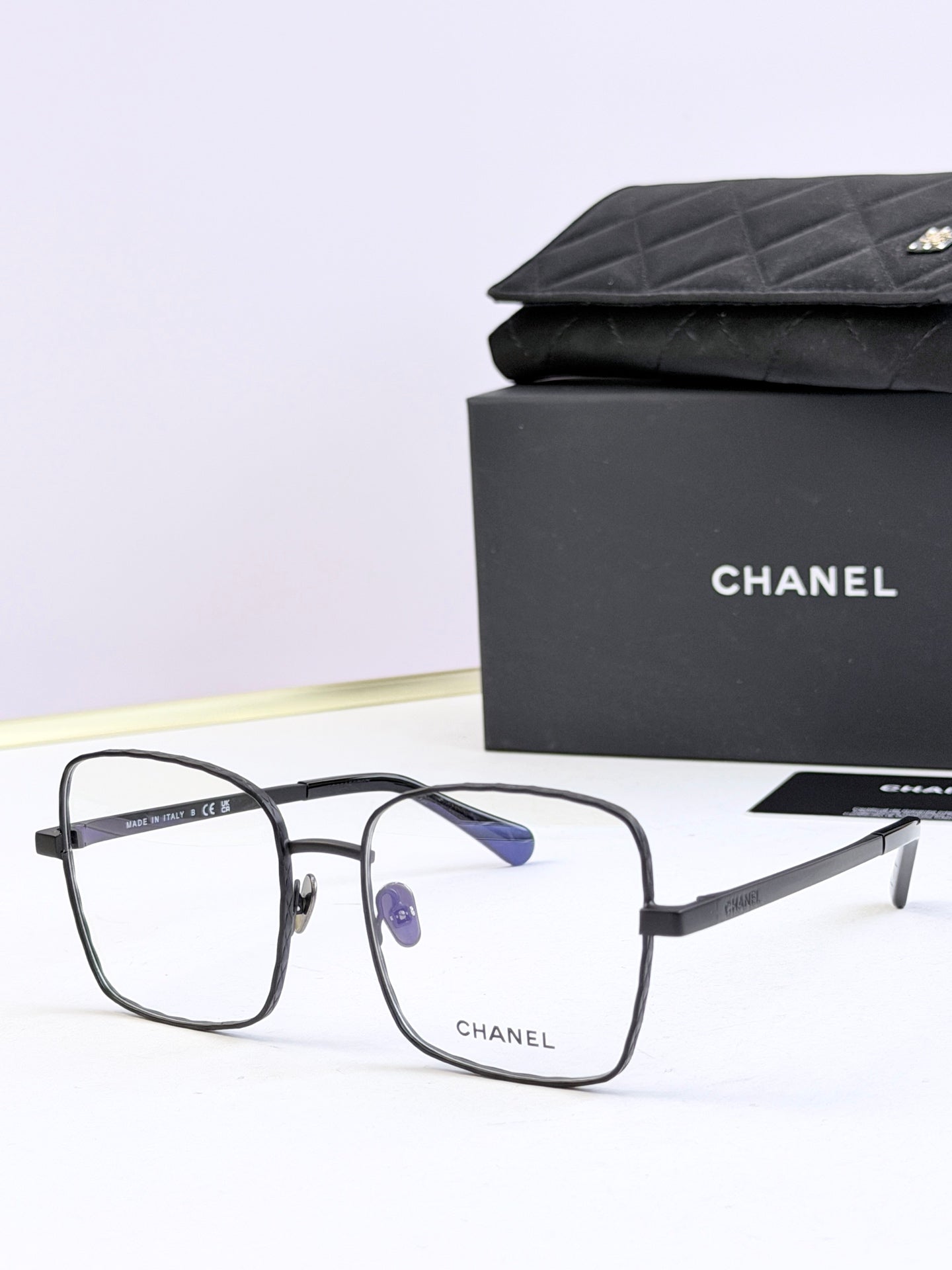Chanel square eyeglasses with black frames and blue tinted lenses