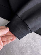 Black jogger cuff close-up with elastic hem and stitched seam