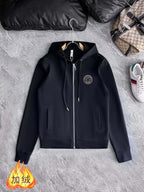 Black hooded zip-up jacket with drawstring cords and circular chest logo patch