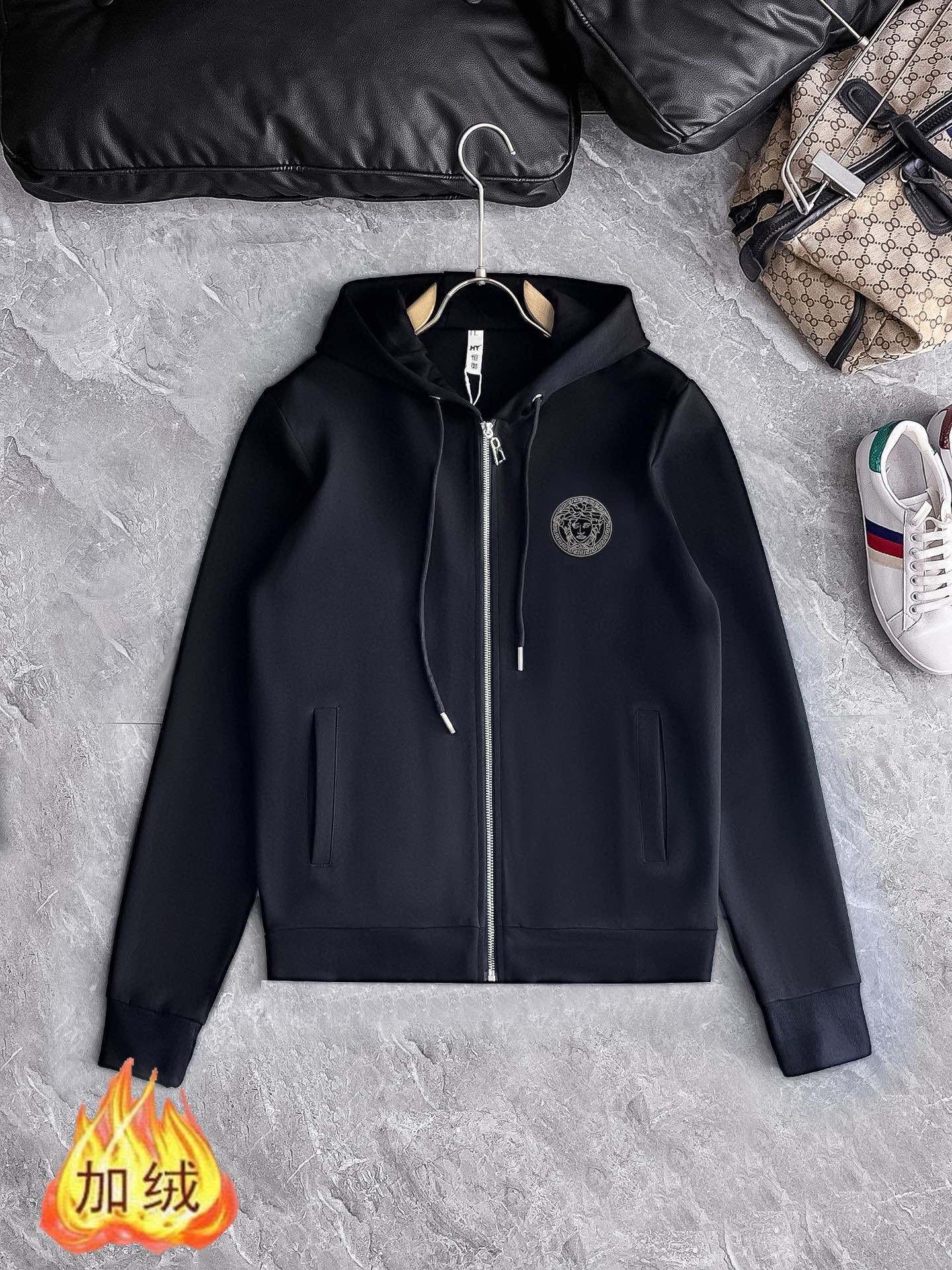 Black hooded zip-up jacket with drawstring cords and circular chest logo patch