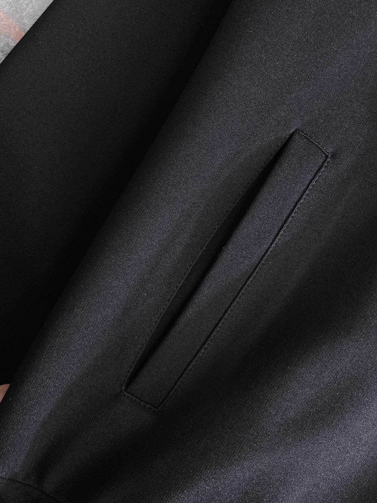 Black fabric close-up with visible side seam and smooth matte finish