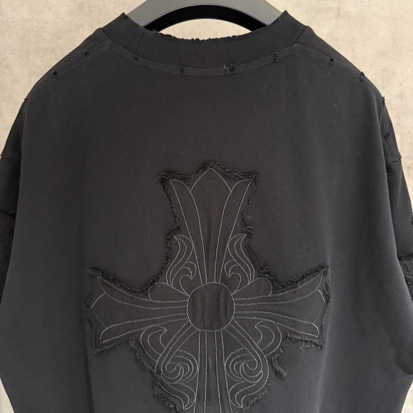 Black short-sleeve T-shirt close-up of large cross embroidery on back