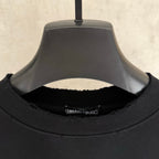 Black short-sleeve T-shirt close-up of ribbed crew neck with inner label