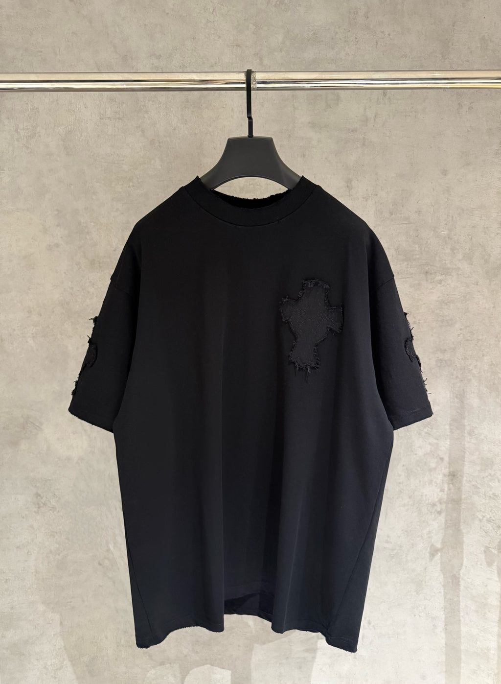 Black short-sleeve T-shirt with distressed sleeves and small cross applique on chest